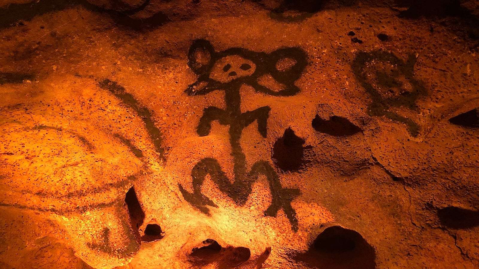 Pictografías taínas pintadas en la roca de la Cueva de las Maravillas, con luz cálida