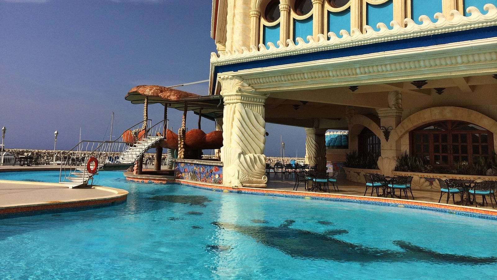 Piscina azul frente al edificio de estilo palaciego de Ocean World, en Puerto Plata